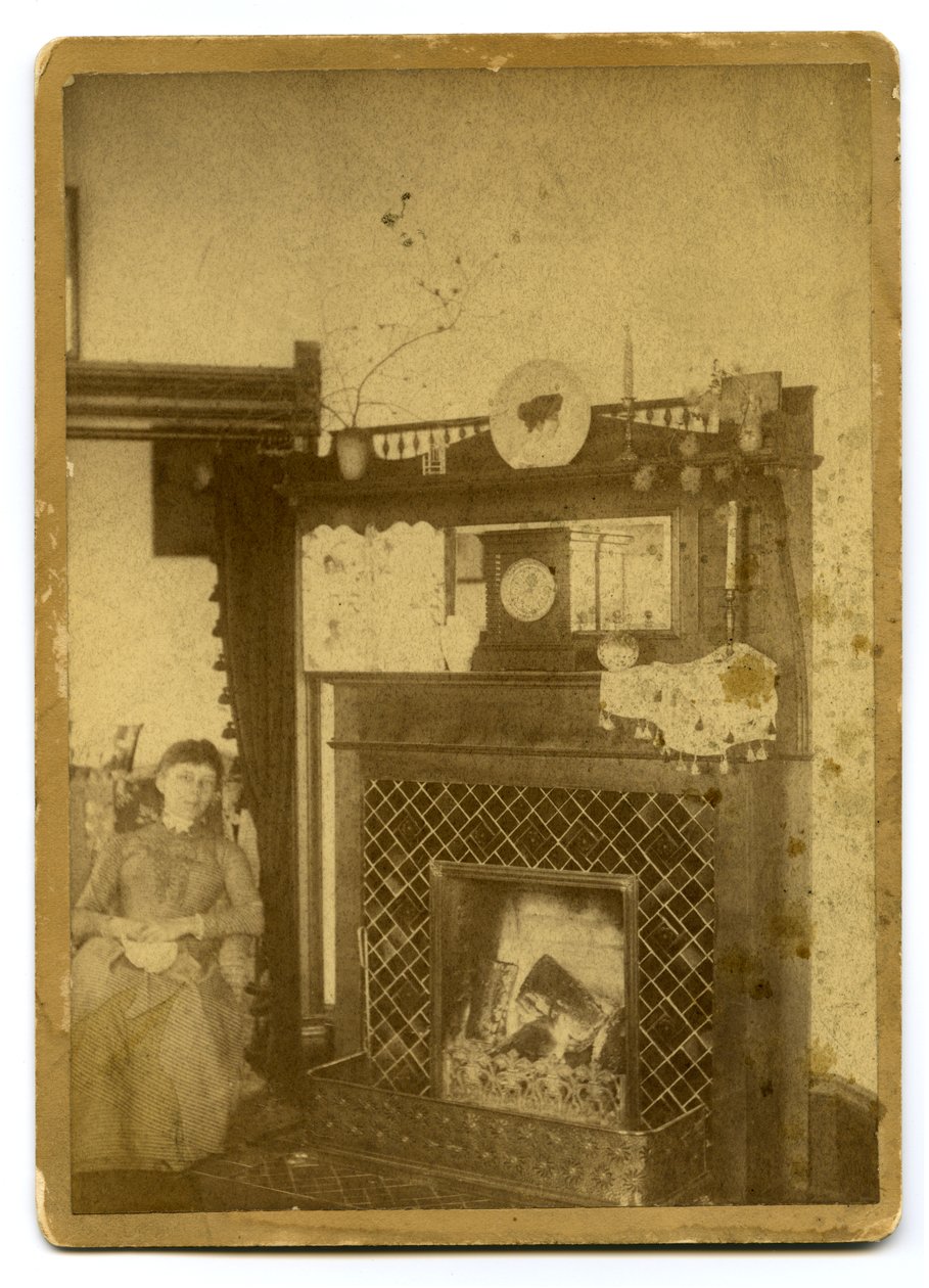 Woman Seated Beside a Lit Fireplace by Unknown