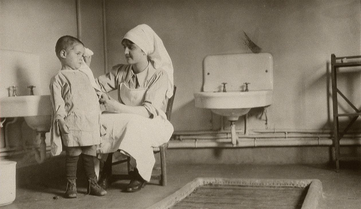 Nurse Tending a Sick Child at Passay and Saint-Quentin Colonies for Refugees and Orphans, 1919 by American Photographer
