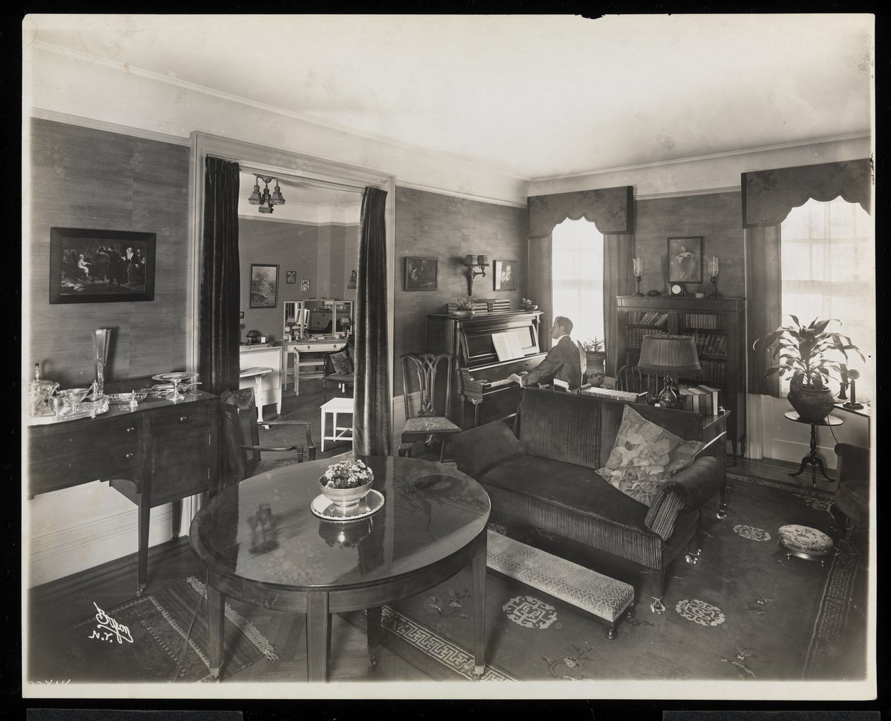A Man Playing the Piano in a Living Room of the A.C. Cronin Residence by Byron Company