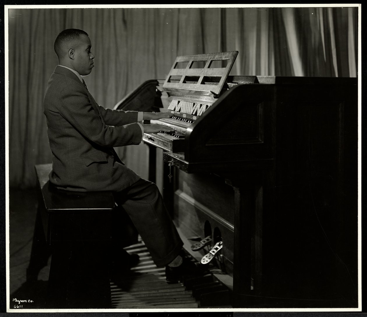 African American man playing the organ at the New York Association for the Blind, 111 East 59th Street, New York by Byron Company