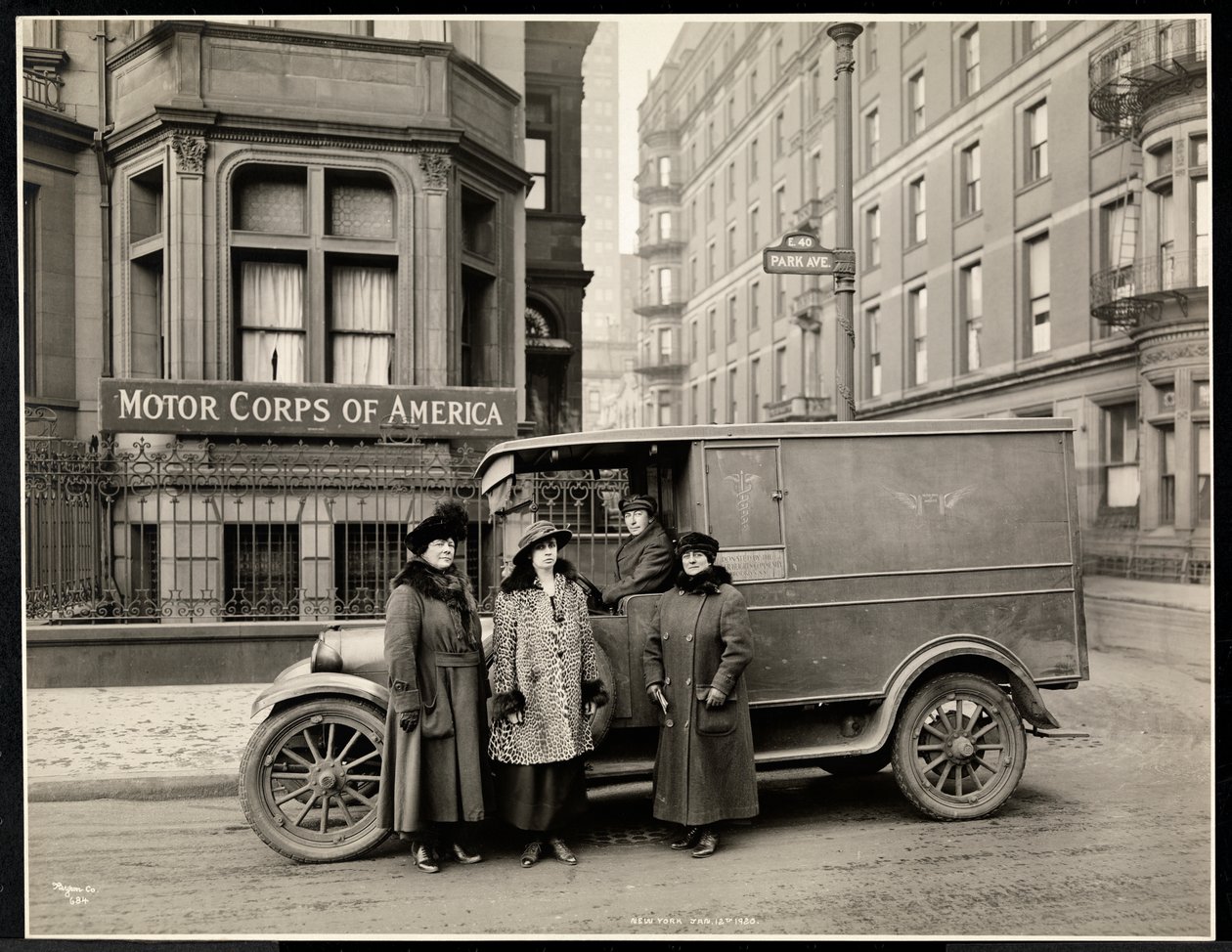 Four women of the Motor Corps of America standing in front of an ambulance on Park Avenue at 40th Street in front of the Motor Corps of America building, New York by Byron Company