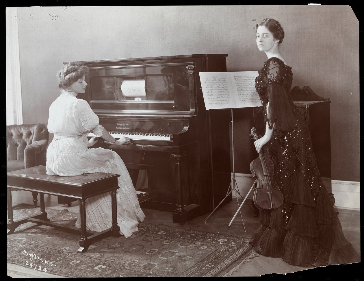 Women playing a player piano and a violin, New York, 1907 by Byron Company