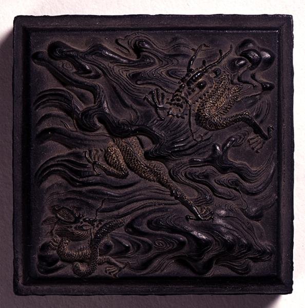 Ink-cake in seal form with a domed knop moulded in dramatic relief with two dragons among waves, attributed to Wang Wei-kao, Ching dynasty, Hui-chou, Anhui by Chinese School