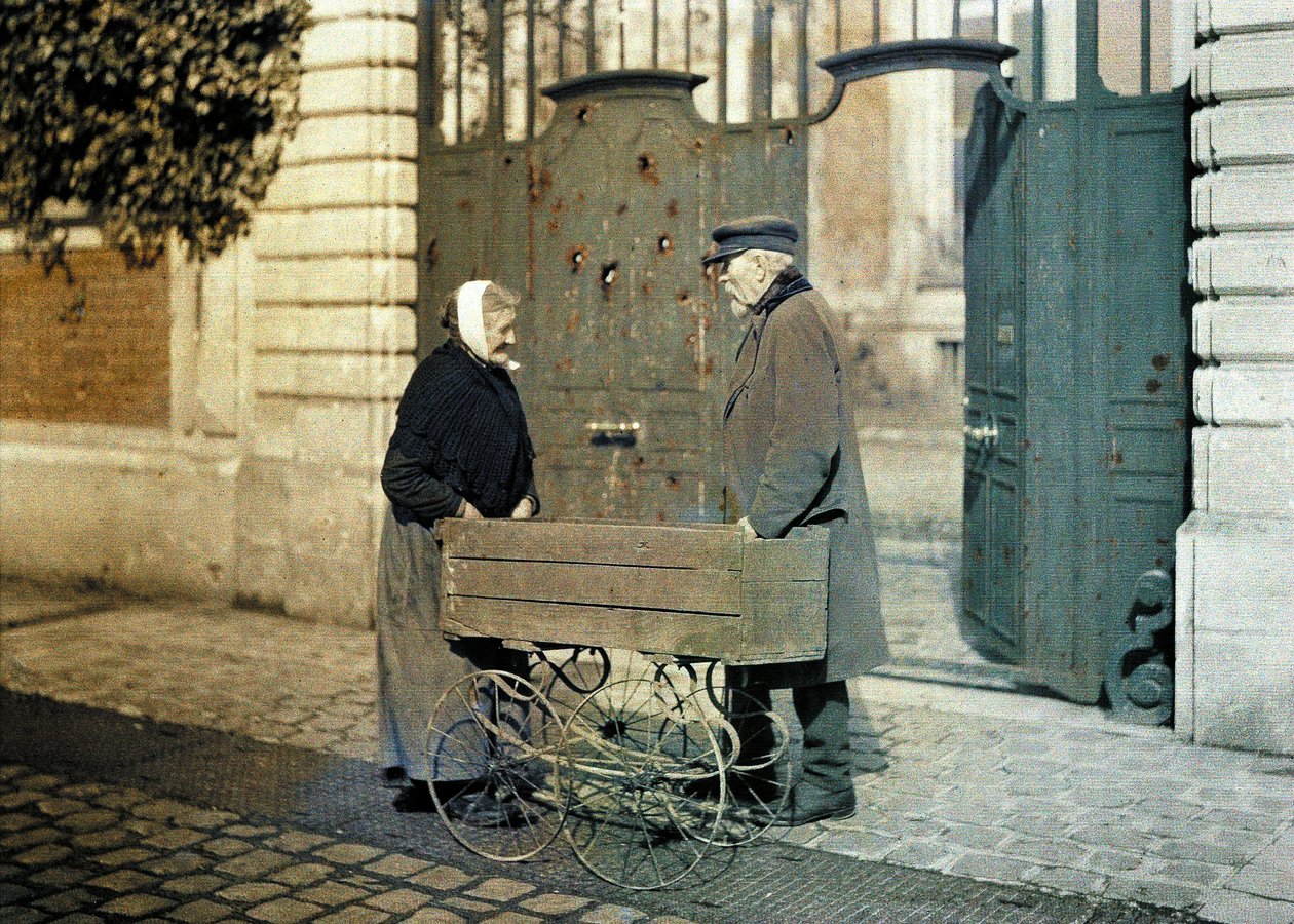 Two Senior Citizens of Reims, an Old Woman and Mr. Reiser, Standing in Front of a Gate with Many Bullet Holes, Reims, Marne, France, 1917 by Fernand Cuville