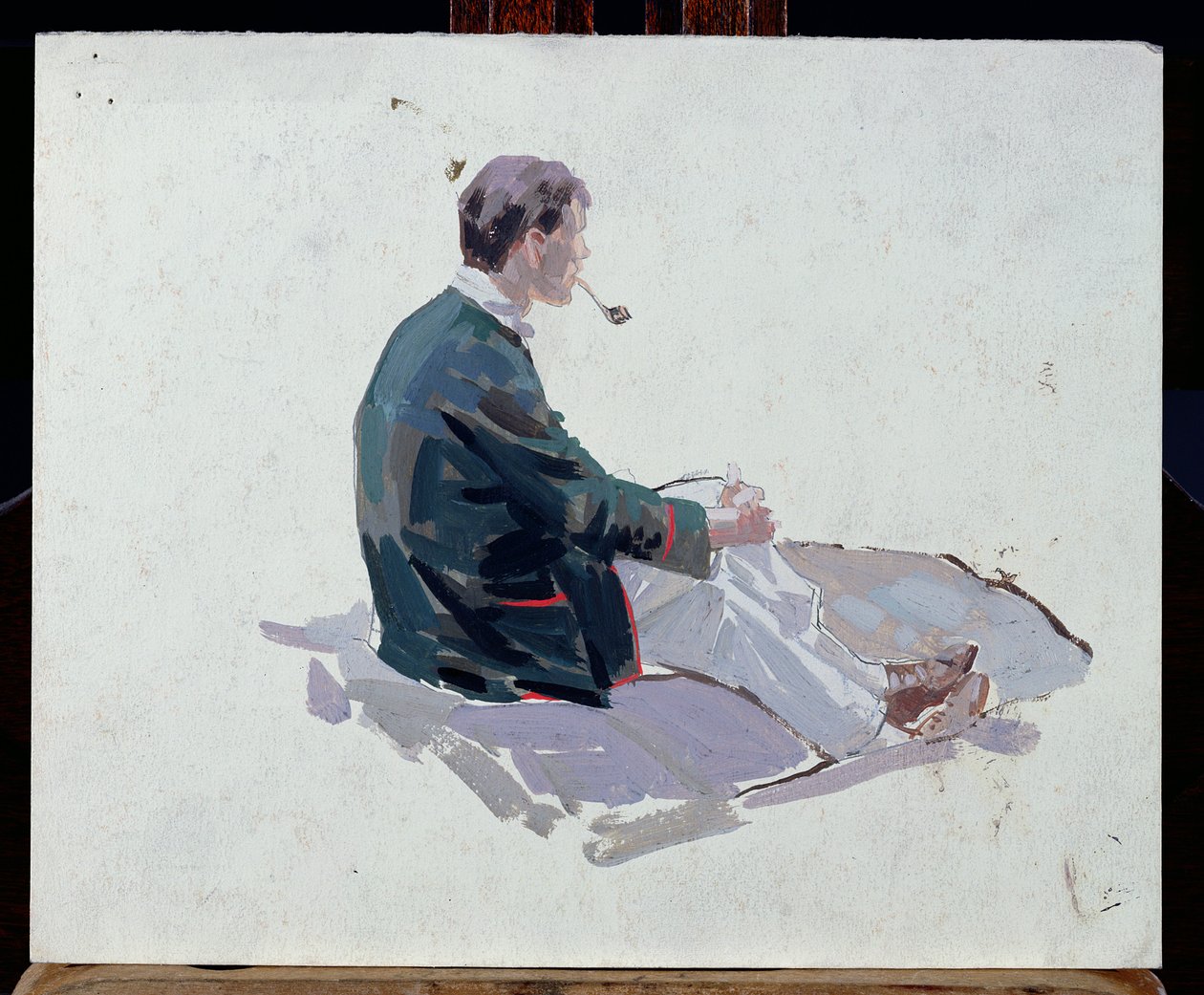 Man sitting upon rocks smoking a pipe by Harry Watson