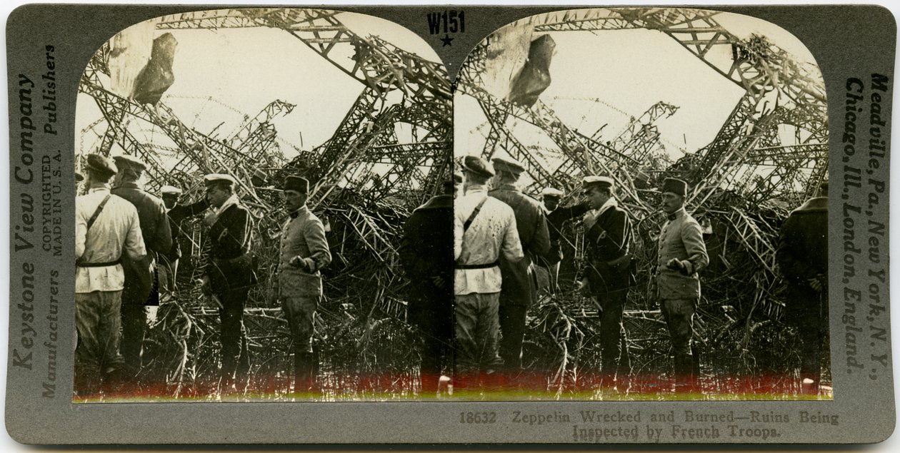 Horizontal, sepia stereocard showing group of uniformed men surveying the wreckage of a zeppelin. Keystone Stereograph number 18632. The title reads by Keystone View Company