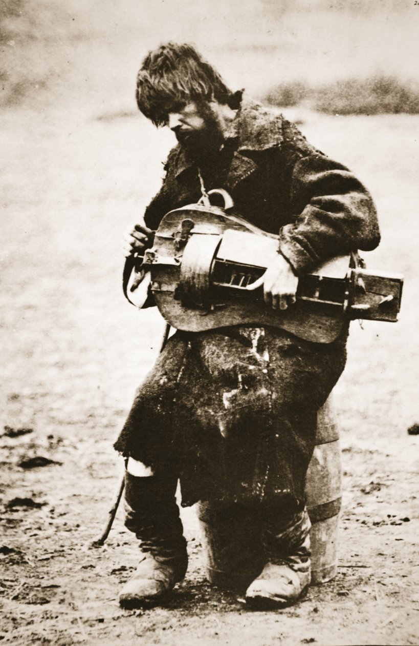 Russian peasant playing hurdy gurdy, c.1880s by Russian Photographer