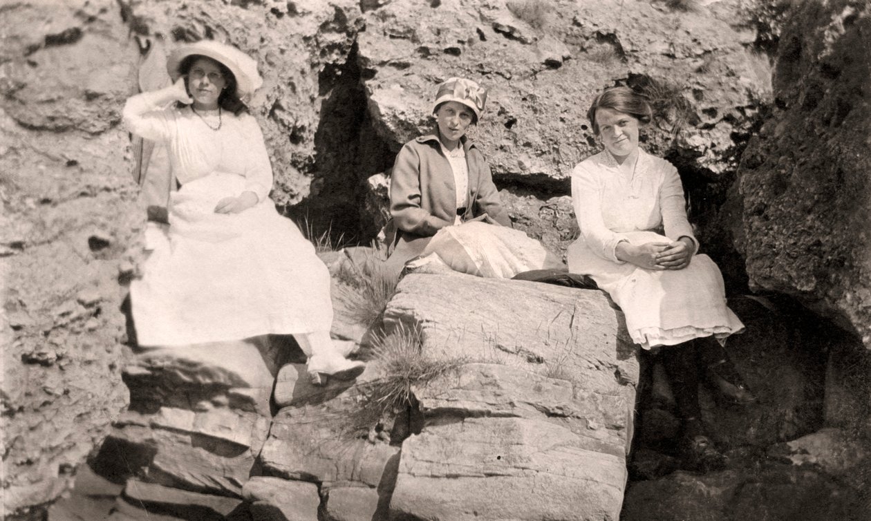 Three Women Relaxing on Rocks by Unbekannt