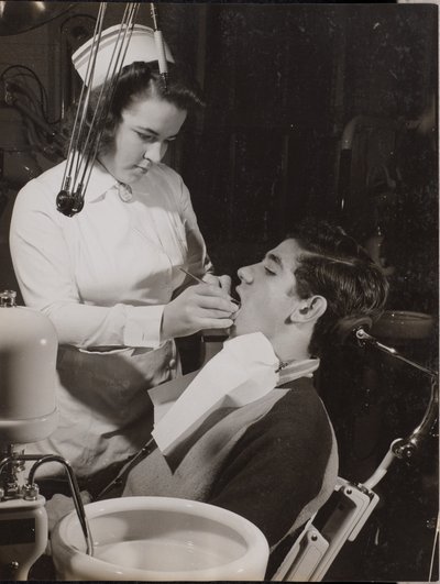 Dental Hygienist Inspects a Patient