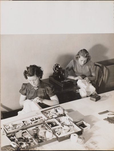 Two women sew fabric by hand by Arnold Eagle