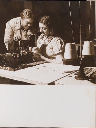 Two Women Use a Sewing Machine by Arnold Eagle