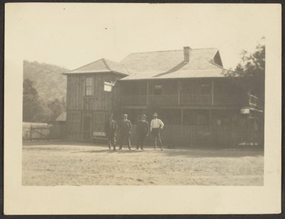 Four Men before Wooden Building by Louis Fleckenstein