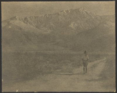 Woman Walking on Path Towards Mountains by Louis Fleckenstein