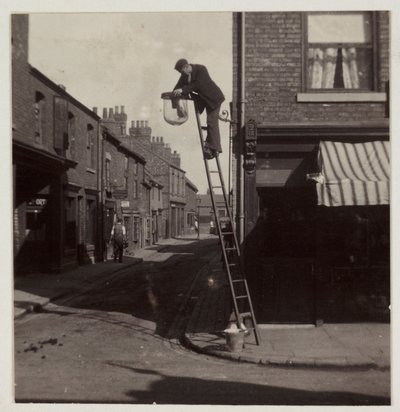 Man cleaning a gas street light, c 1905 by Unbekannt