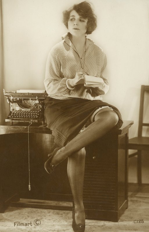 Secretary sitting on a desk by English Photographer